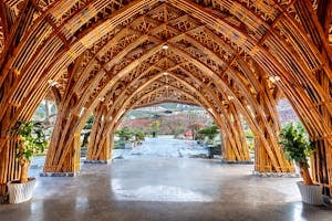 A striking bamboo pavilion showcases intricate architecture against a serene backdrop.