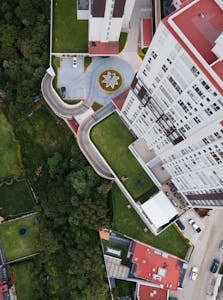 Aerial view of urban residential buildings with surrounding green spaces and roads.